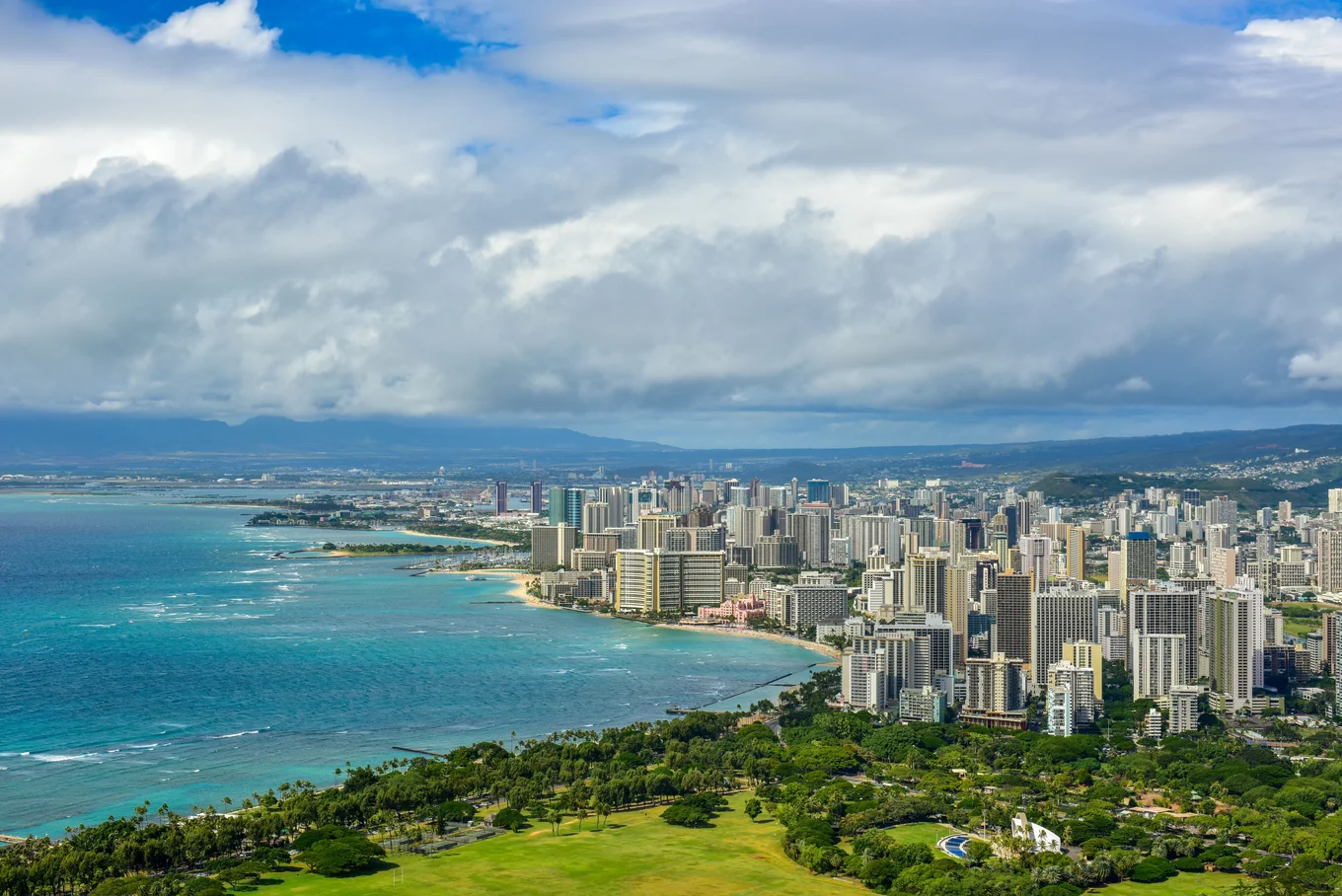 City skyline with tall buildings, coastline, and ocean.