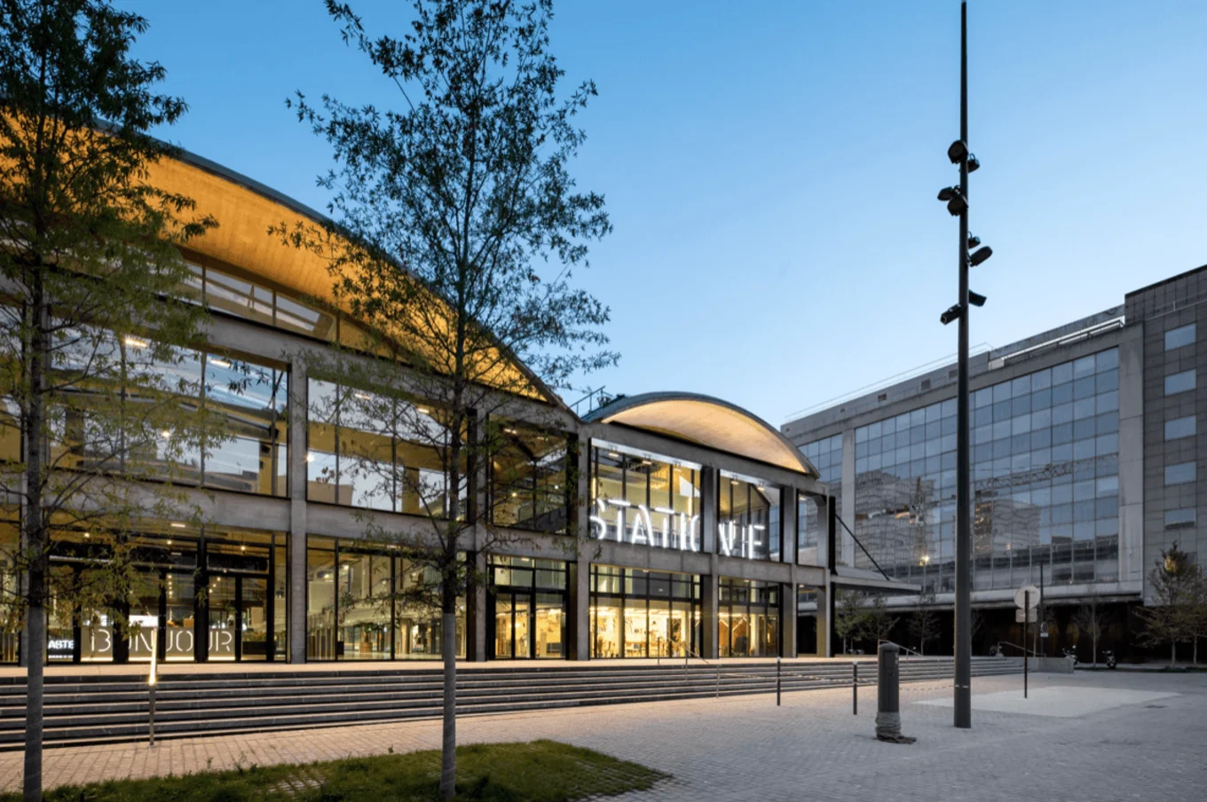 Modern building, glass facade, trees, "STATION F" text.