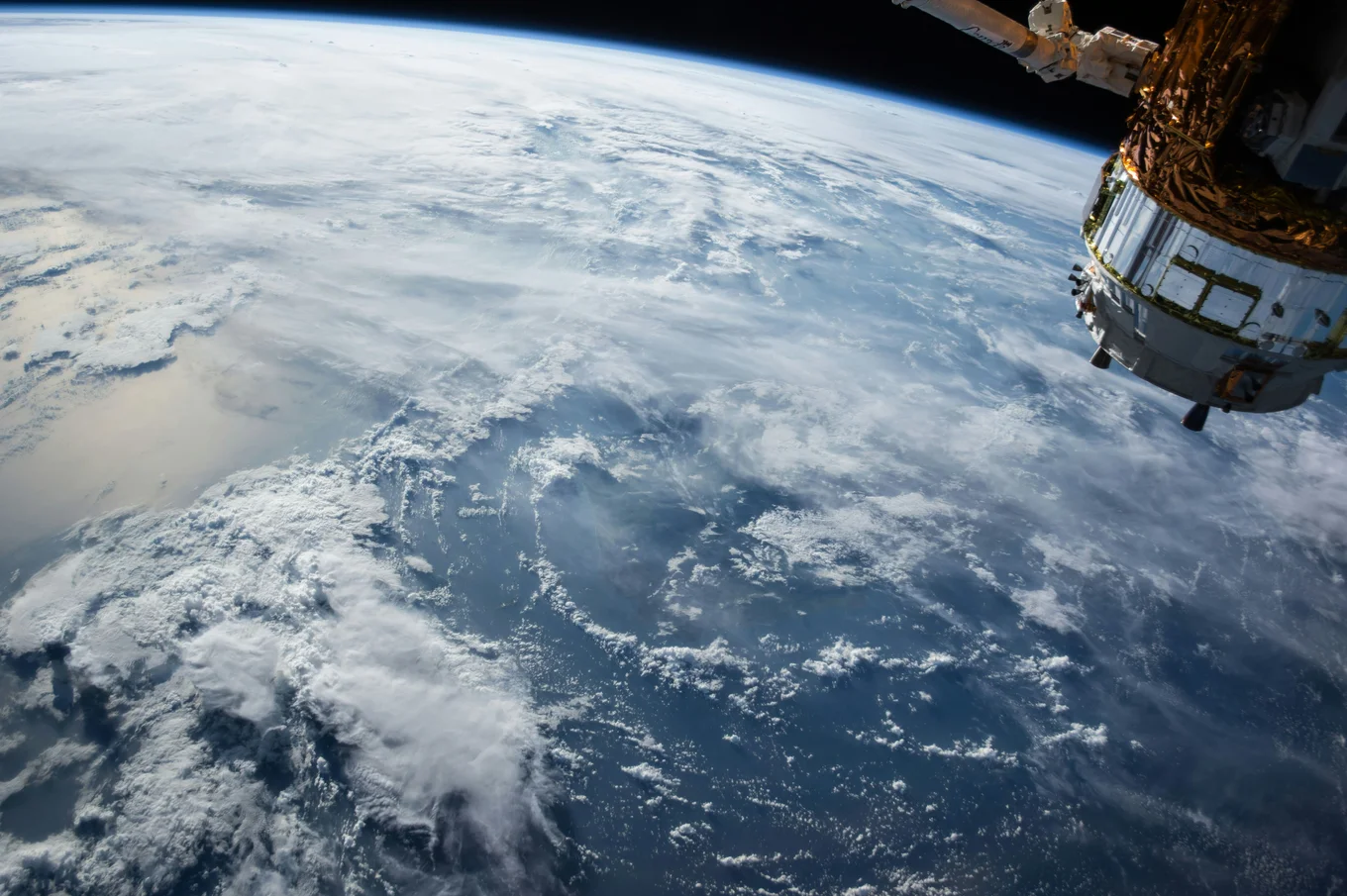 The earth viewed from space with a satellite in the upper right-hand corner.